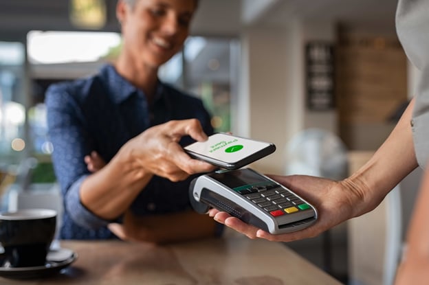 Person making a contactless payment via mobile phone