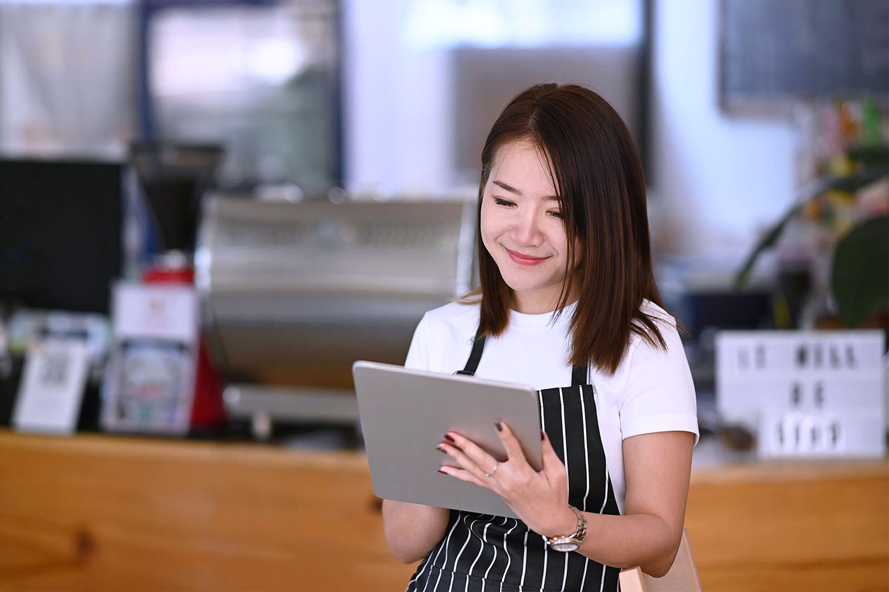 Cutout photo of a waitress looking down at a tablet.