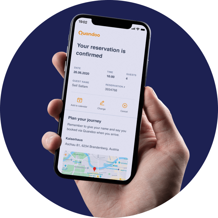Cutout image of a smartphone held in a hand. The screen shows a confirmation email from Quandoo with 'Your reservation is confirmed' and additional info about the reservation.